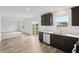 Modern kitchen featuring stainless steel appliances, dark cabinets, and a view to the living room at 10416 Crystal Coop Ln, Indianapolis, IN 46235