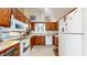 An efficient kitchen features wooden cabinets, white appliances, and tile flooring at 1067 Acadia Ct, Indianapolis, IN 46217