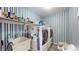 Functional laundry room with blue-striped walls, washer, dryer and storage shelves at 1067 Acadia Ct, Indianapolis, IN 46217