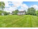 Expansive backyard featuring a well-maintained lawn, mature trees, and a charming home with raised garden beds at 1130 E 105Th St, Carmel, IN 46280