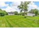 Large, grassy backyard with a shed, a fire pit area, and a view of the home, perfect for outdoor activities at 1130 E 105Th St, Carmel, IN 46280