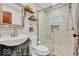 Modern bathroom with a glass-enclosed shower, floating shelves, and a pedestal sink, offering a fresh and clean aesthetic at 1130 E 105Th St, Carmel, IN 46280