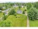Aerial view showcasing a home with a large front lawn, mature trees, and a long gravel driveway at 1130 E 105Th St, Carmel, IN 46280