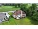 Aerial view of a well-maintained brick home with a wooden deck, set amidst lush greenery and a golf course at 1326 Pebble Brook Dr, Noblesville, IN 46062