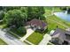 Aerial view of a brick home with manicured lawn near a pond and golf course, providing an outdoor lifestyle at 1326 Pebble Brook Dr, Noblesville, IN 46062