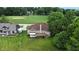 Aerial shot of a brick home with a wooden deck, surrounded by green lawns, trees, and a golf course at 1326 Pebble Brook Dr, Noblesville, IN 46062