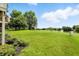 Lush green backyard with trees, a pond, and a well-manicured lawn at 1326 Pebble Brook Dr, Noblesville, IN 46062
