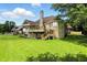 View of a large brick home, showcasing a wooden deck and screened porch, nestled in a well-manicured lawn at 1326 Pebble Brook Dr, Noblesville, IN 46062