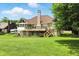 Spacious backyard with a large brick home featuring a wooden deck and screened porch, perfect for outdoor living at 1326 Pebble Brook Dr, Noblesville, IN 46062