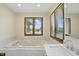 Bright bathroom features large soaking tub, large windows with views, and quartz countertops at 1326 Pebble Brook Dr, Noblesville, IN 46062