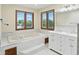 Bright bathroom offers double sinks, soaker tub and large windows overlooking the property at 1326 Pebble Brook Dr, Noblesville, IN 46062