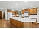 This kitchen offers wood cabinetry, stainless appliances, large island with cooktop, and hardwood floors at 1326 Pebble Brook Dr, Noblesville, IN 46062