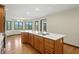 Kitchen island with cooktop overlooks the dining area and features wood cabinets, stainless appliances and hardwood floors at 1326 Pebble Brook Dr, Noblesville, IN 46062