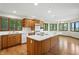 Spacious kitchen features wood cabinets, stainless appliances, island with cooktop, and hardwood floors at 1326 Pebble Brook Dr, Noblesville, IN 46062