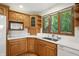 Kitchen offers wood cabinetry, stainless appliances, sink, dishwasher, microwave and views of the yard at 1326 Pebble Brook Dr, Noblesville, IN 46062