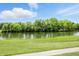 Scenic view of a tranquil pond surrounded by lush green trees and grass at 1326 Pebble Brook Dr, Noblesville, IN 46062