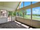 Enclosed sunroom with wood flooring and large windows showcasing views of the golf course and pond at 1326 Pebble Brook Dr, Noblesville, IN 46062