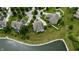 Expansive aerial view of a neighborhood featuring lush green lawns, mature trees, and a tranquil lake at 13895 Cloverfield Cir, Fishers, IN 46038