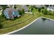 Aerial view of a home's backyard featuring a spacious lawn, mature trees, and a serene pond at 13895 Cloverfield Cir, Fishers, IN 46038