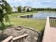 Beautiful backyard with a stone patio, a fire pit, and a view of the pond at 13895 Cloverfield Cir, Fishers, IN 46038