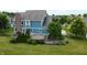 Landscaped backyard featuring a brick chimney, patio, manicured trees, and serene yard at 13895 Cloverfield Cir, Fishers, IN 46038