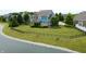 Manicured backyard featuring a black fence, serene pond, and vibrant green lawn at 13895 Cloverfield Cir, Fishers, IN 46038