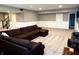 Cozy basement with plush carpeting, chair railing, and a large, comfortable sectional sofa at 13895 Cloverfield Cir, Fishers, IN 46038