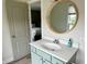 Bathroom with a decorative mirror over the sink, green cabinet, and views into the bedroom at 13895 Cloverfield Cir, Fishers, IN 46038
