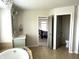 Bathroom featuring a tub, single sink, decorative mirror, and view to bedroom at 13895 Cloverfield Cir, Fishers, IN 46038