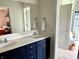 Bright bathroom featuring a double sink with blue cabinets and views into the bedroom and toilet room at 13895 Cloverfield Cir, Fishers, IN 46038