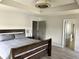 Spacious bedroom with wood-look floors, tray ceiling, ceiling fan, and wood bed frame at 13895 Cloverfield Cir, Fishers, IN 46038