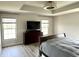 Bedroom featuring a tray ceiling, wood floors, television, and dresser at 13895 Cloverfield Cir, Fishers, IN 46038
