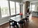 Bright dining room with a stone fireplace, a rustic table, modern lighting, and large windows at 13895 Cloverfield Cir, Fishers, IN 46038