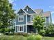 A bright blue two-story home with pristine landscaping, lush green lawn and white trim at 13895 Cloverfield Cir, Fishers, IN 46038