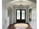 Welcoming foyer with dark wood floors, modern light fixture, and an arched entryway at 13895 Cloverfield Cir, Fishers, IN 46038