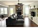 Comfortable living room area with a fireplace, TV, hardwood floors, sectional sofa, and natural light at 13895 Cloverfield Cir, Fishers, IN 46038