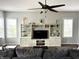Bright living room with large built-in shelving and modern ceiling fan at 13895 Cloverfield Cir, Fishers, IN 46038