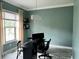 Home office featuring a crystal chandelier, black desk and chair, window and muted-green painted walls at 13895 Cloverfield Cir, Fishers, IN 46038