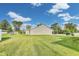 A large green backyard on a sunny day offers plenty of space for outdoor activities at 1396 Lexington Trl, Greenfield, IN 46140