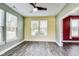 Bright living room featuring natural light, gray floors and adjacent bonus room with red accent wall at 1396 Lexington Trl, Greenfield, IN 46140