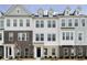 Modern townhome featuring a brick and white facade with large windows and a welcoming entrance at 14521 Hanford Ln, Carmel, IN 46074