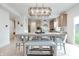 Bright dining area featuring modern chandelier, counter seating, and view into the kitchen at 15192 Montfort Dr, Noblesville, IN 46062