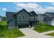 Two-story home showcasing dark siding, a well-maintained lawn, and an attached two-car garage at 15192 Montfort Dr, Noblesville, IN 46062