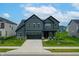 Beautiful two-story home featuring dark siding, a well-maintained lawn, and an attached two-car garage at 15192 Montfort Dr, Noblesville, IN 46062