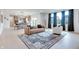 Open-concept living room showcasing a stylish rug, comfortable seating, and a view of the modern kitchen at 15192 Montfort Dr, Noblesville, IN 46062