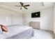Bright main bedroom featuring tray ceiling, fan, TV, and gray color scheme at 15192 Montfort Dr, Noblesville, IN 46062