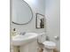 Stylish powder room featuring pedestal sink, modern fixtures, and elegant wall art at 15192 Montfort Dr, Noblesville, IN 46062