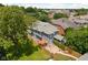A lush backyard with mature trees surrounding a two-story home and patio at 1531 N College Ave, Indianapolis, IN 46202