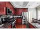 Modern kitchen featuring stainless steel appliances, granite countertops, and a dark wood cabinetry at 1531 N College Ave, Indianapolis, IN 46202