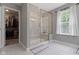 The bathroom features a glass-enclosed shower, walk-in closet, and a window for natural light at 15546 Senita Ln, Fishers, IN 46037